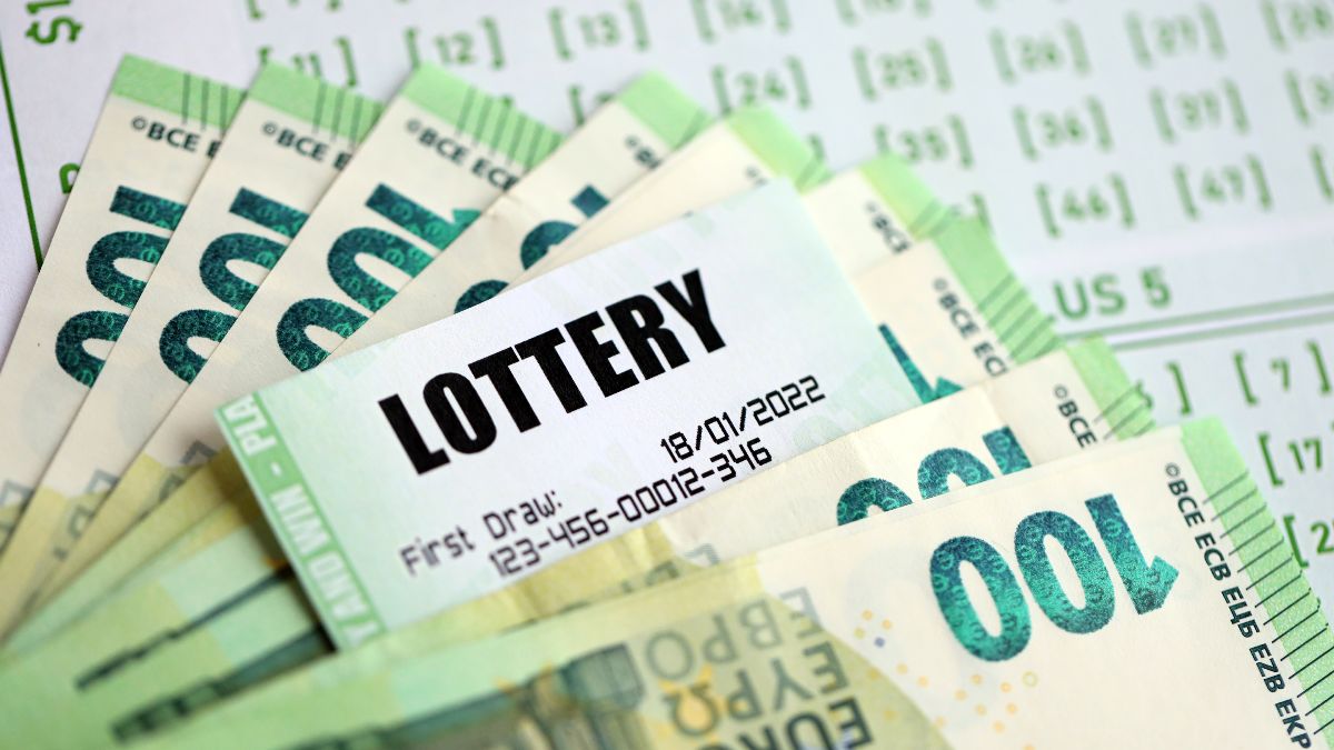 Boleto de lotería junto a billetes de 100 euros Boleto de lotería junto a billetes de 100 euros