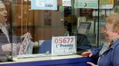Una mujer comprando lotería en una administración